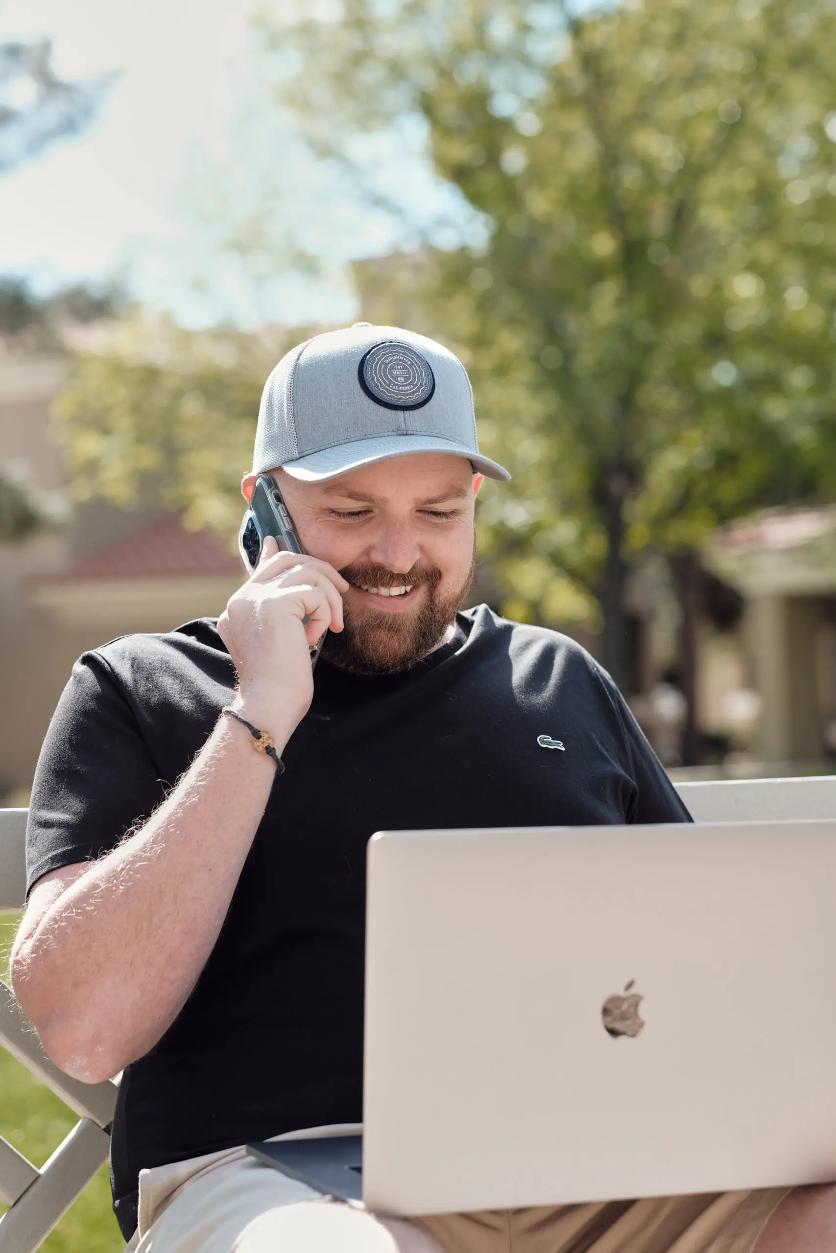 Gavin Timms working outdoors on a phone call with a laptop